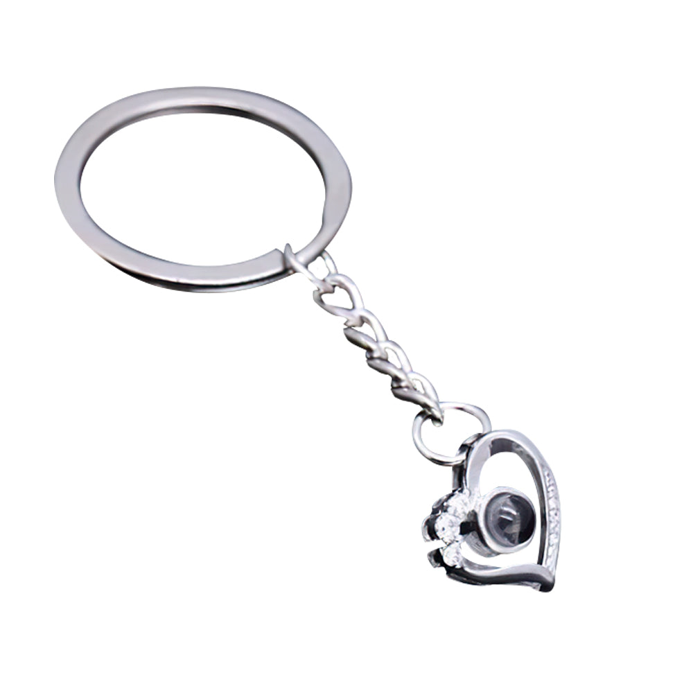 Heart projection keyring projecting a clear photo using a phone torch — demonstration of custom micro-engraved pendant projection