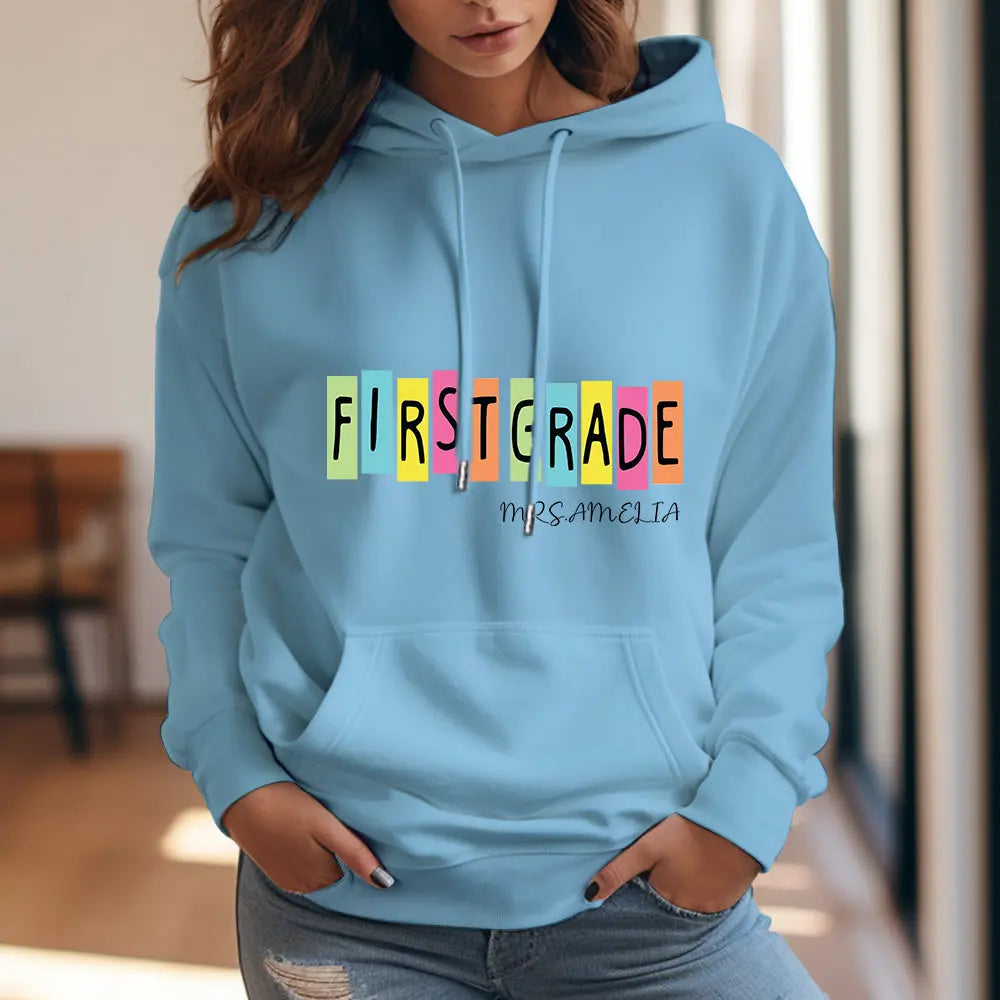 Front and back mockup of personalised first grade hooded sweatshirt showing custom name placement — teacher custom name hoodie (polyester).