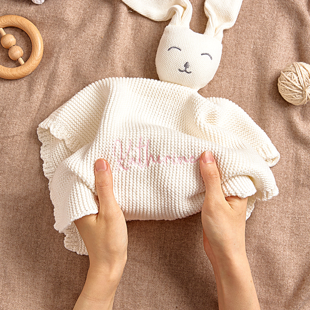 Close-up of the bunny-themed baby towel showing embroidered name on soft cotton fabric.