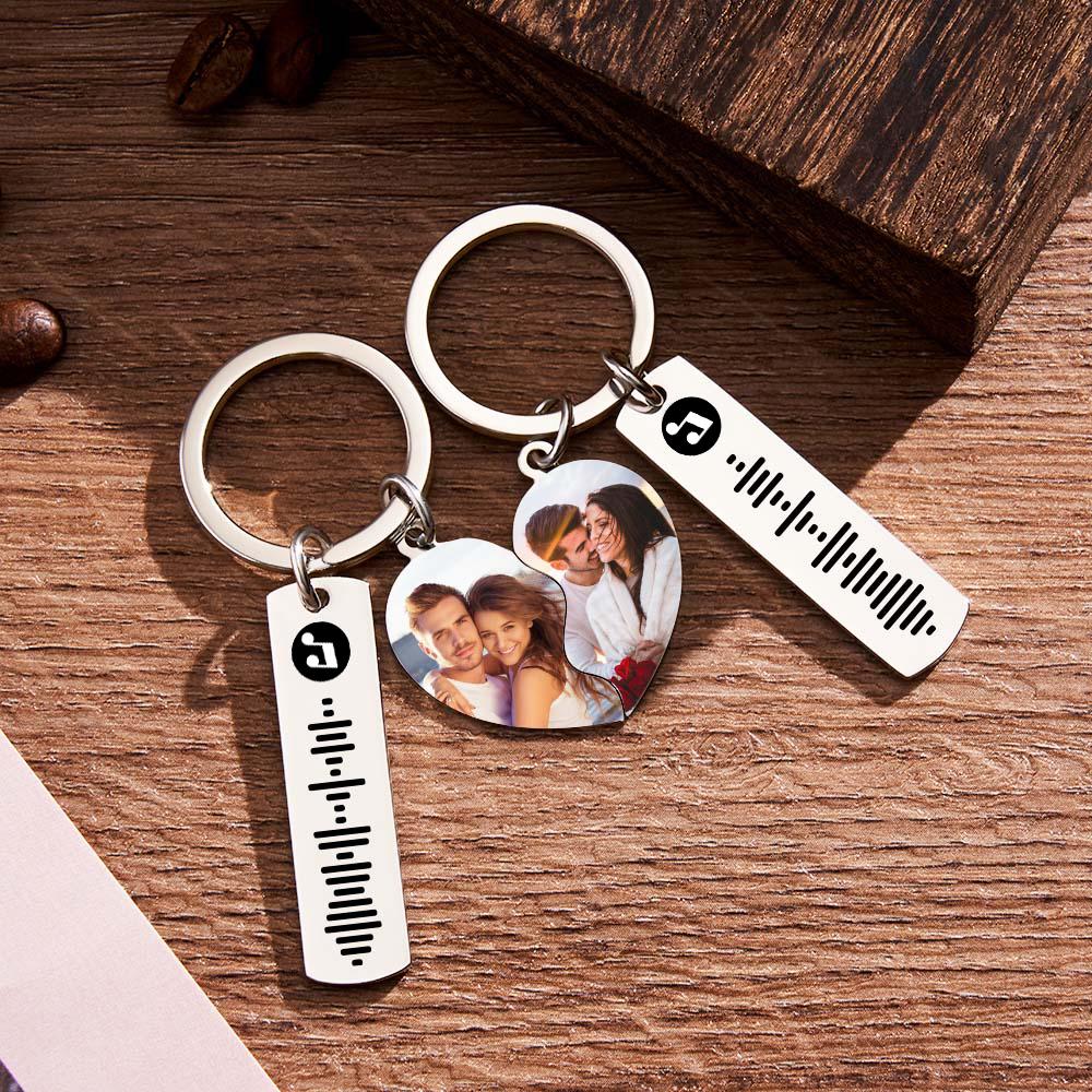 Close-up of laser-cut personalised heart keyrings showing scannable music code engraving and paired design — engraved keepsake keychain for couples