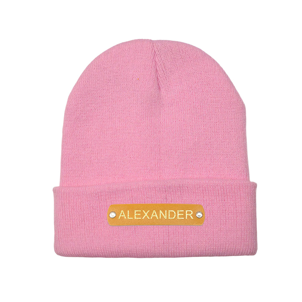 Flat-lay of personalised knitted beanie with leather patch, ideal personalised gift for him or her