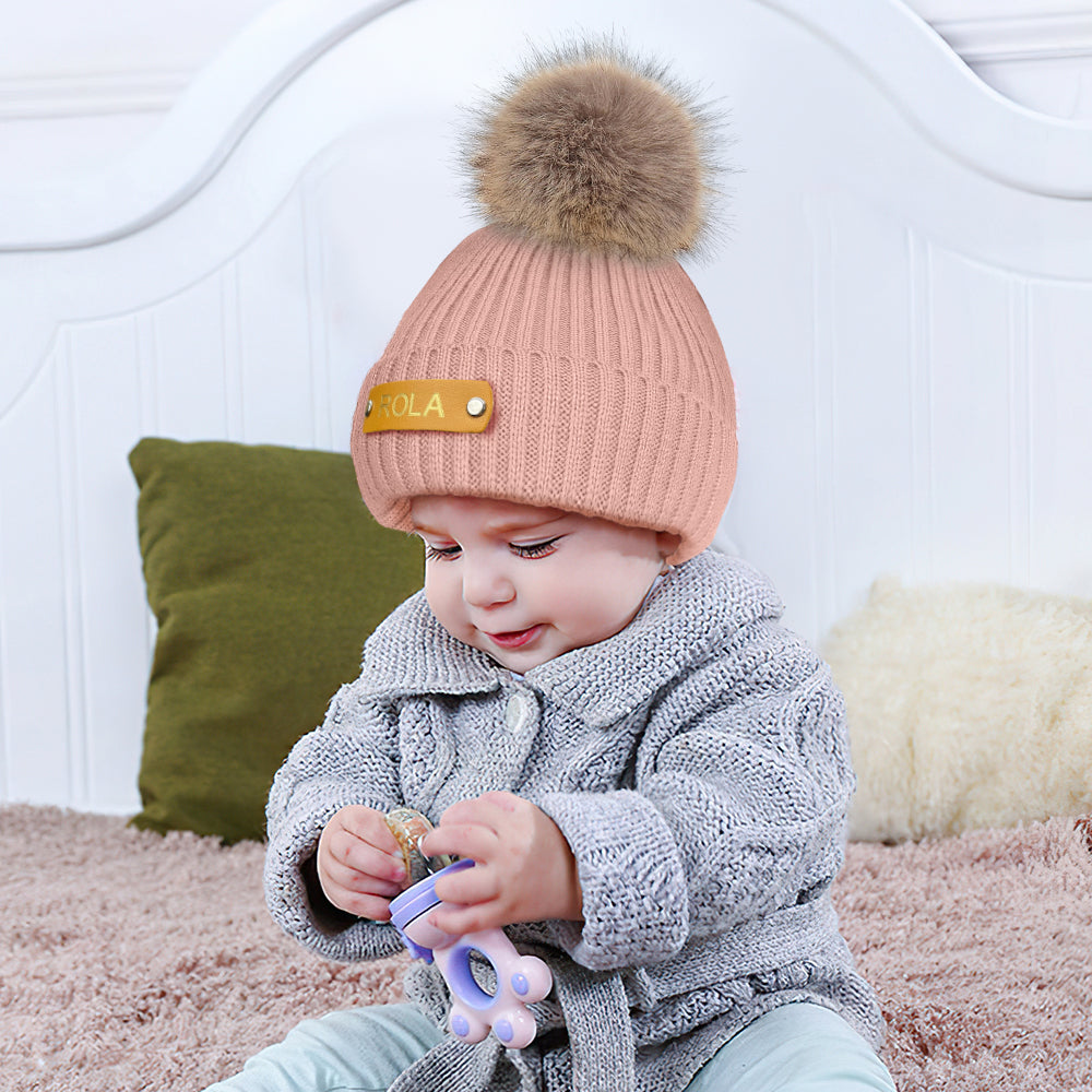 Close-up of leather name patch on personalised beanie showing hot-stamped custom name — premium detail on kids winter hat