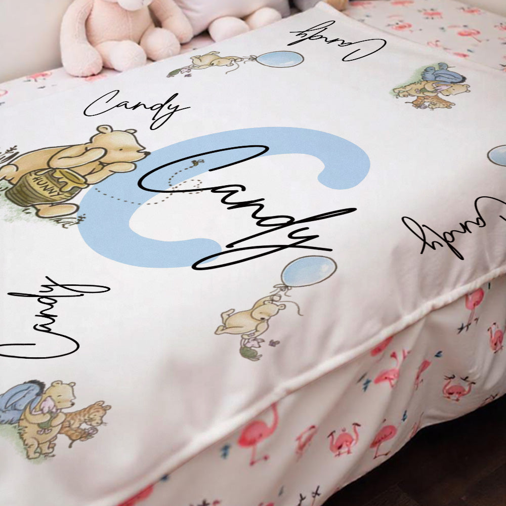 Winnie the Pooh personalised blanket draped over a crib.