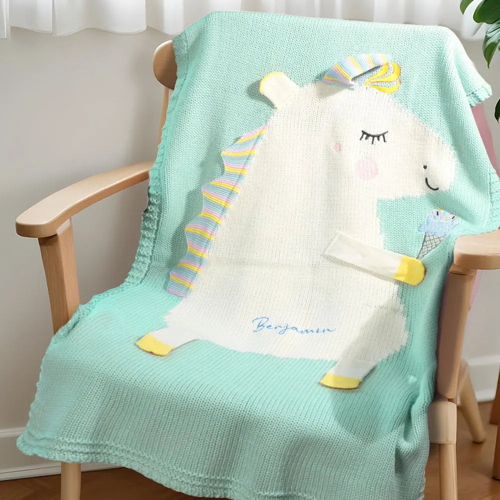 Close-up of embroidery detail showing the name on the unicorn blanket