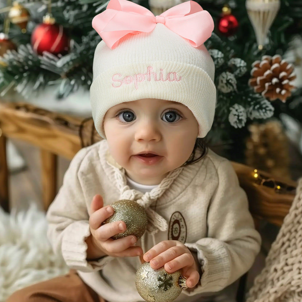Close-up of personalised knitted bow beanie showing neat custom name embroidery and bow detail