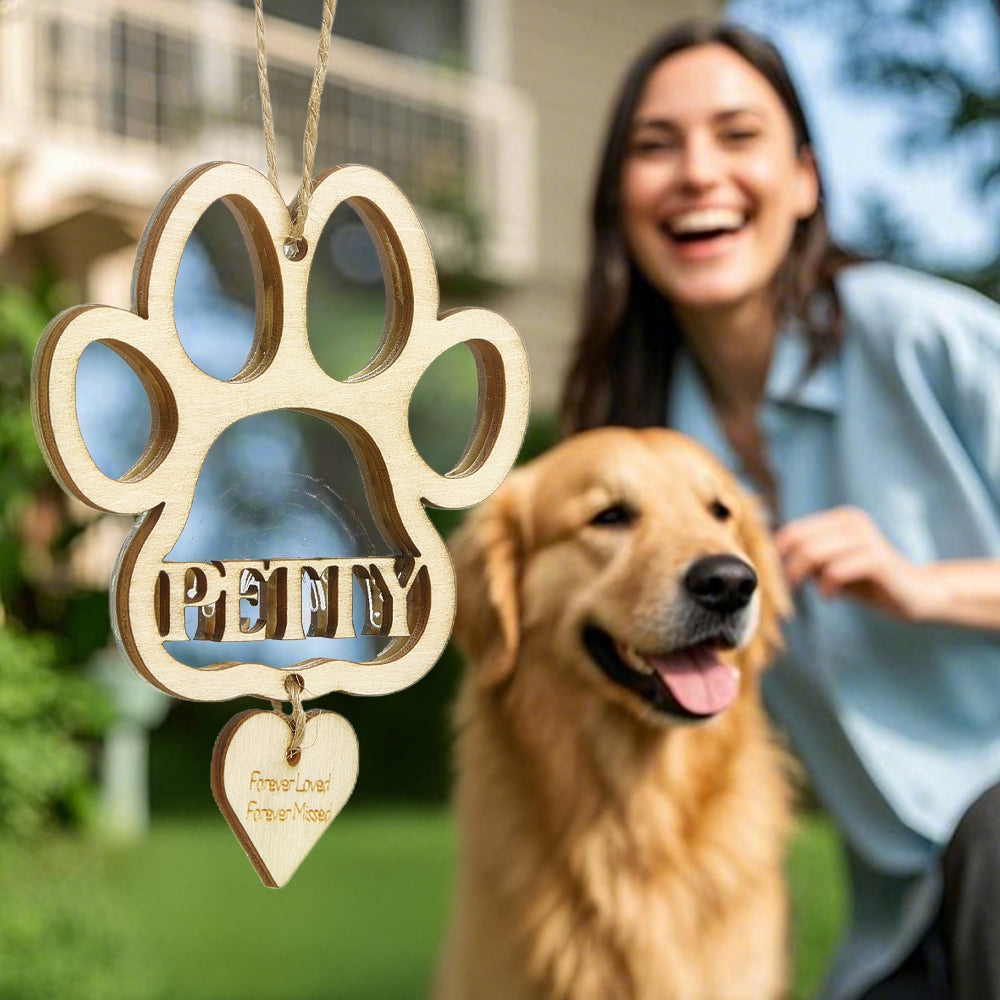 Close-up of carved solid wood dog paw memorial ornament showing deep personalised engraving, durable pet loss keepsake