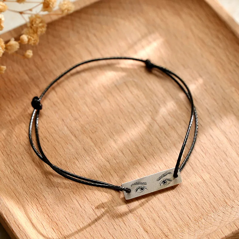 Side view of adjustable stainless steel charm and sliding knot closure on personalised eyes photo bracelet