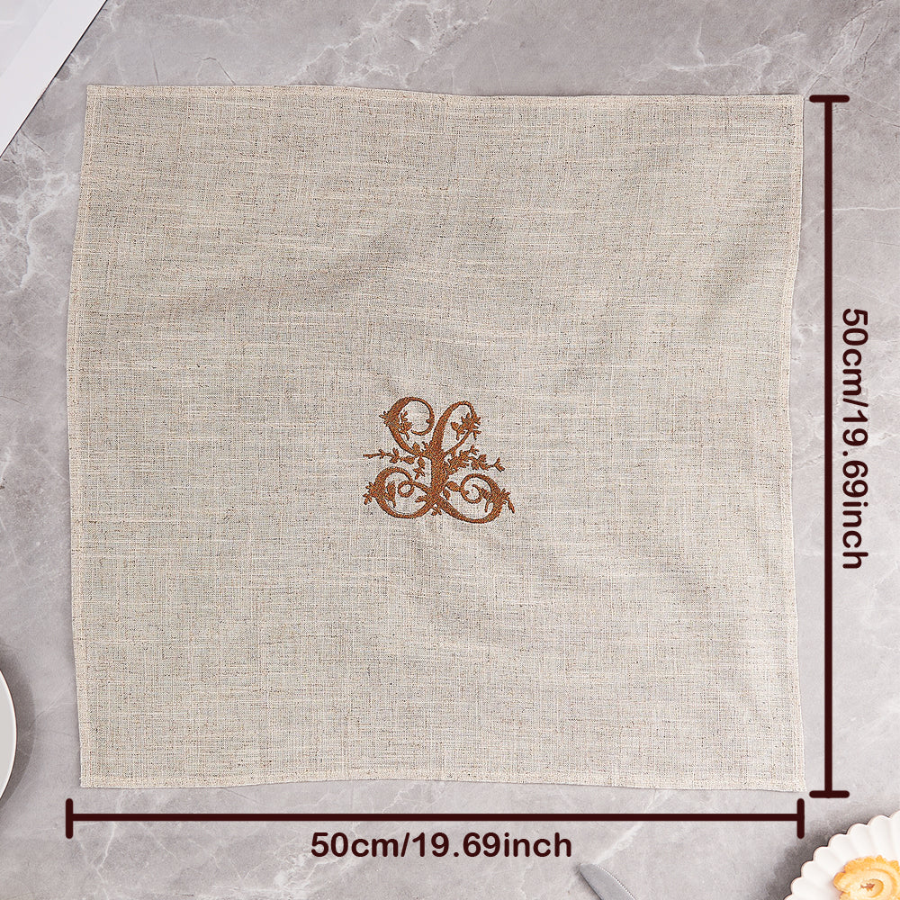Linen napkin with embroidered monogram styled on a dining table for special occasions — refined personalised table accessory