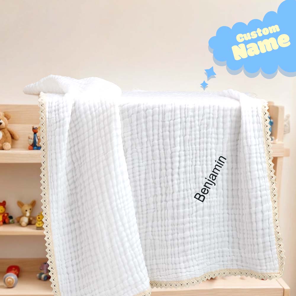 Close-up of the embroidered name on the cosy cotton baby blanket, highlighting precise stitching.