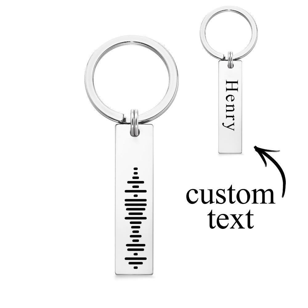 Close-up of precision laser-engraved Spotify music code on stainless steel 3D bar keyring showing scannable code and fine personalised text