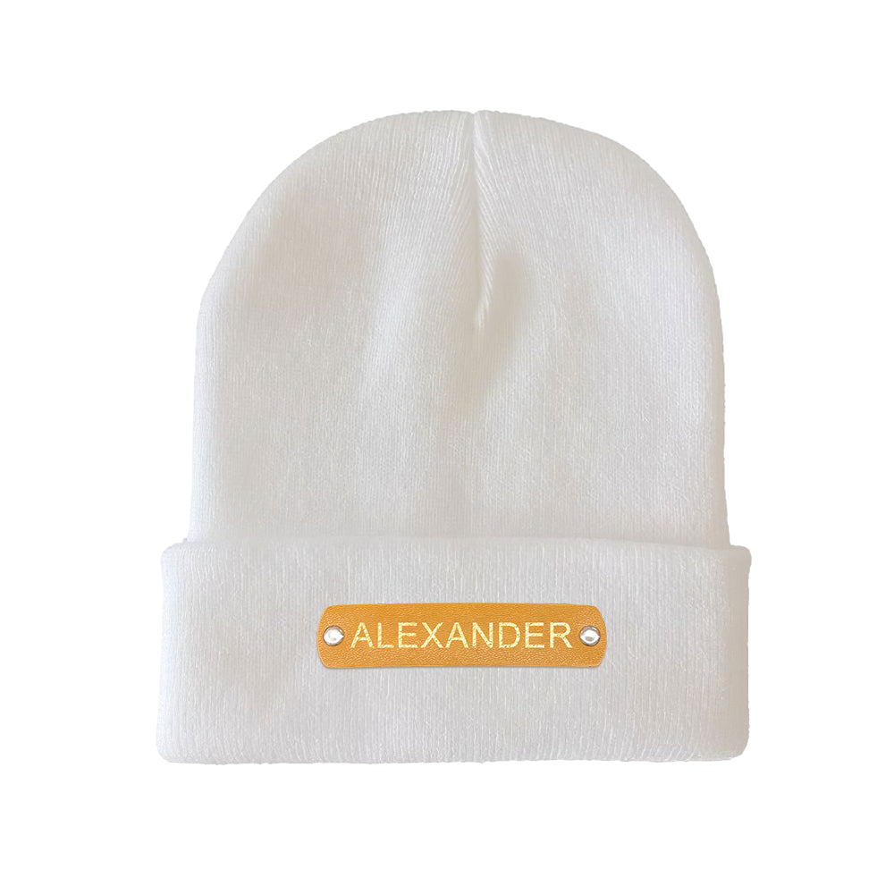 Close-up of hot-stamped leather name patch on personalised beanie showing custom text, neat embossing and stitching detail