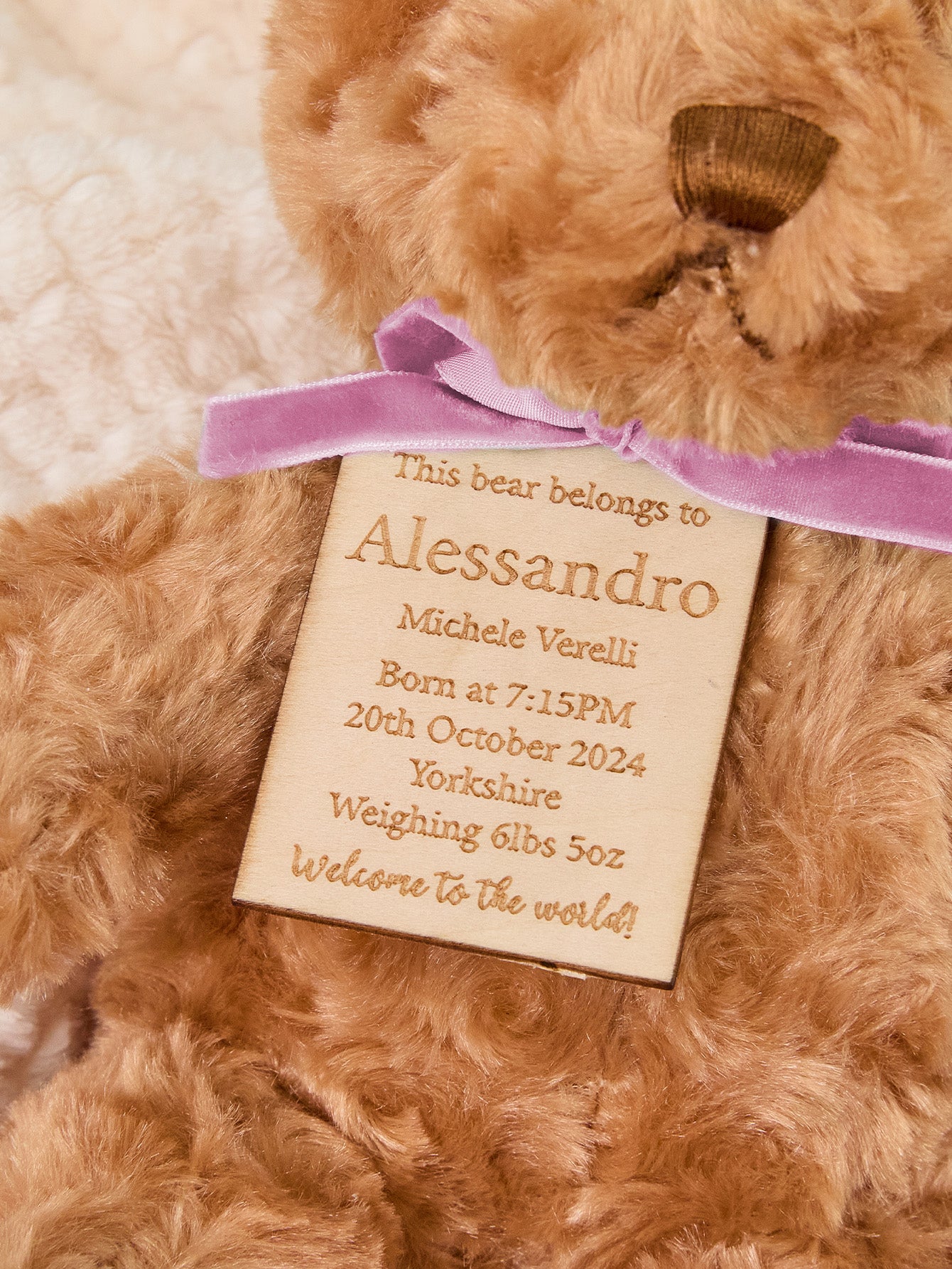 Nursery shelf with personalised embroidered bear beside toys — thoughtful personalised gift for mum and new baby