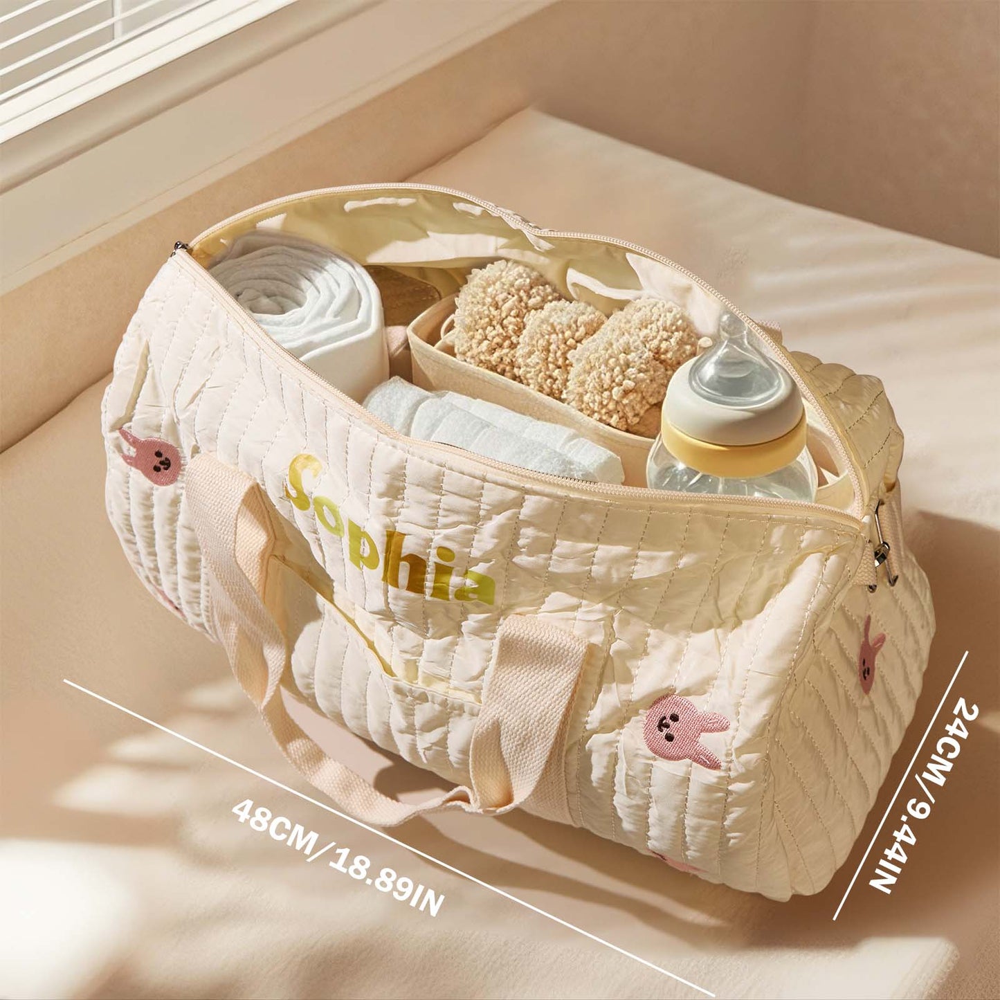 Open personalised maternity hospital bag displaying multiple compartments and organised pockets for nappies, bottles and toiletries.
