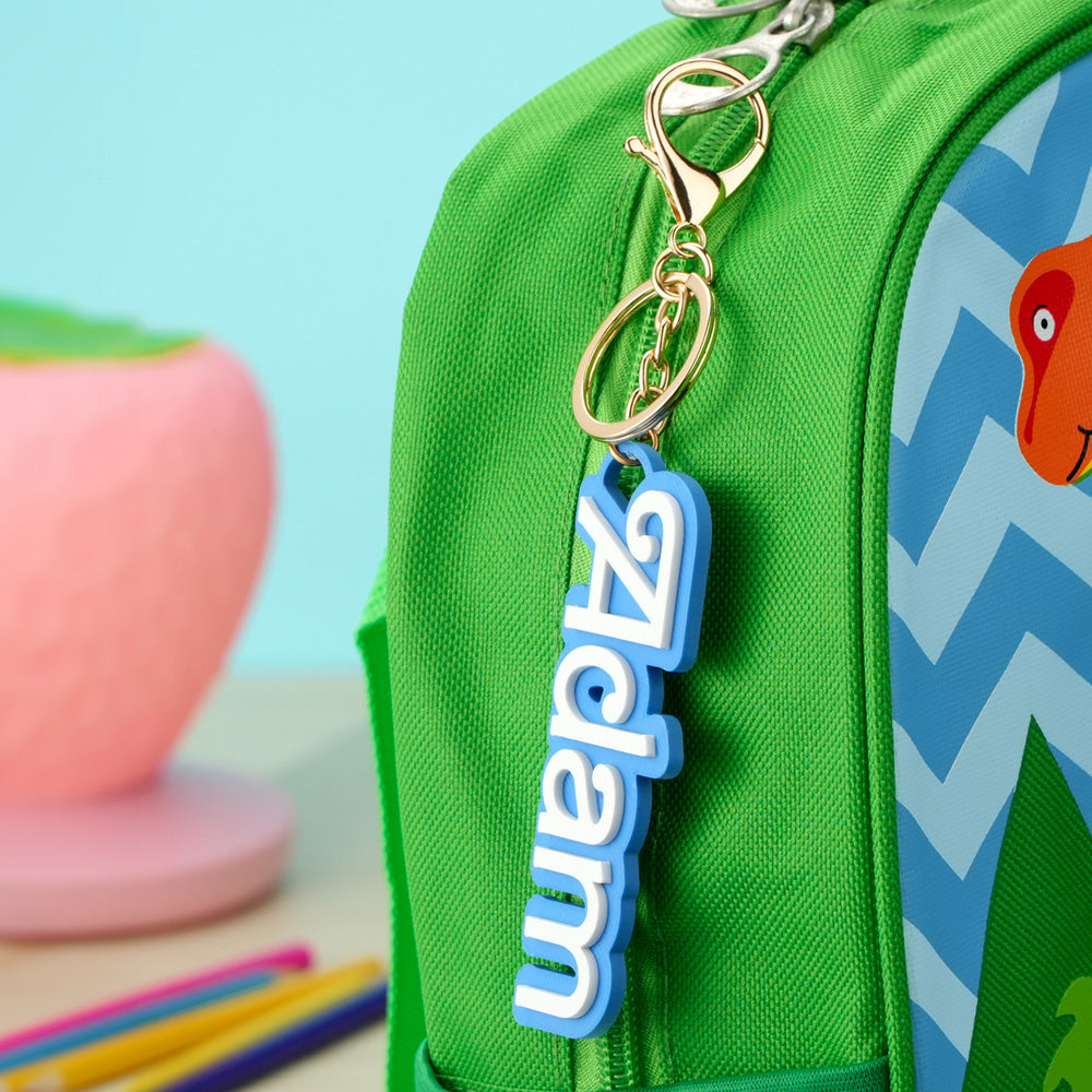 Selection of colourful personalised backpack name tags laid flat displaying different names and fonts ideal back to school gifts