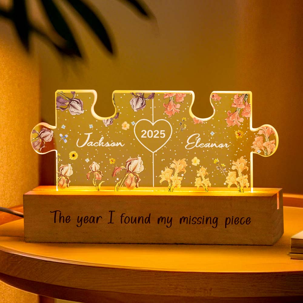 Close-up of personalised couple puzzle night light lit on a bedside table, highlighting precise laser engraving of names and floral motif with durable acrylic and wooden base