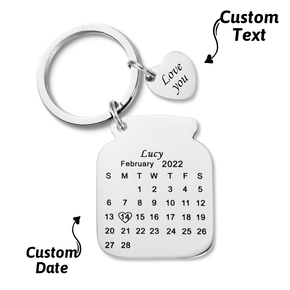 Close-up of precision laser engraving on a personalised anniversary calendar keyring showing names and date on polished steel
