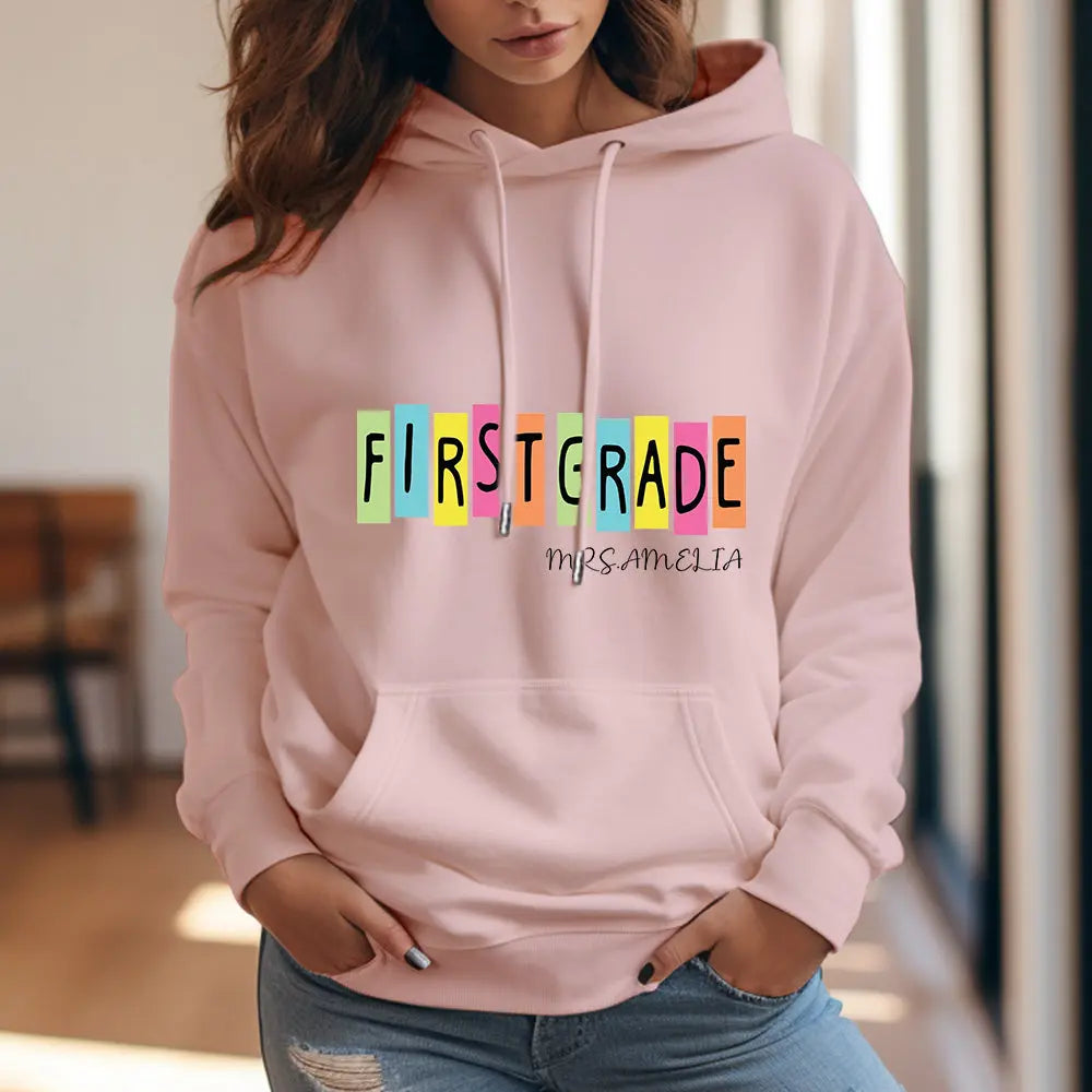 Side view of teacher wearing personalised first grade hoodie with printed name — cosy polyester teacher sweatshirt for classroom use.