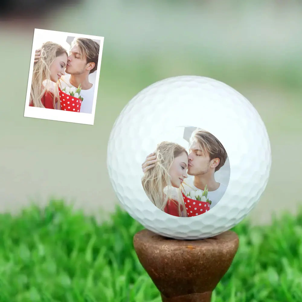 Personalised photo golf ball on tee in grass highlighting aerodynamic dimple pattern and natural play appearance