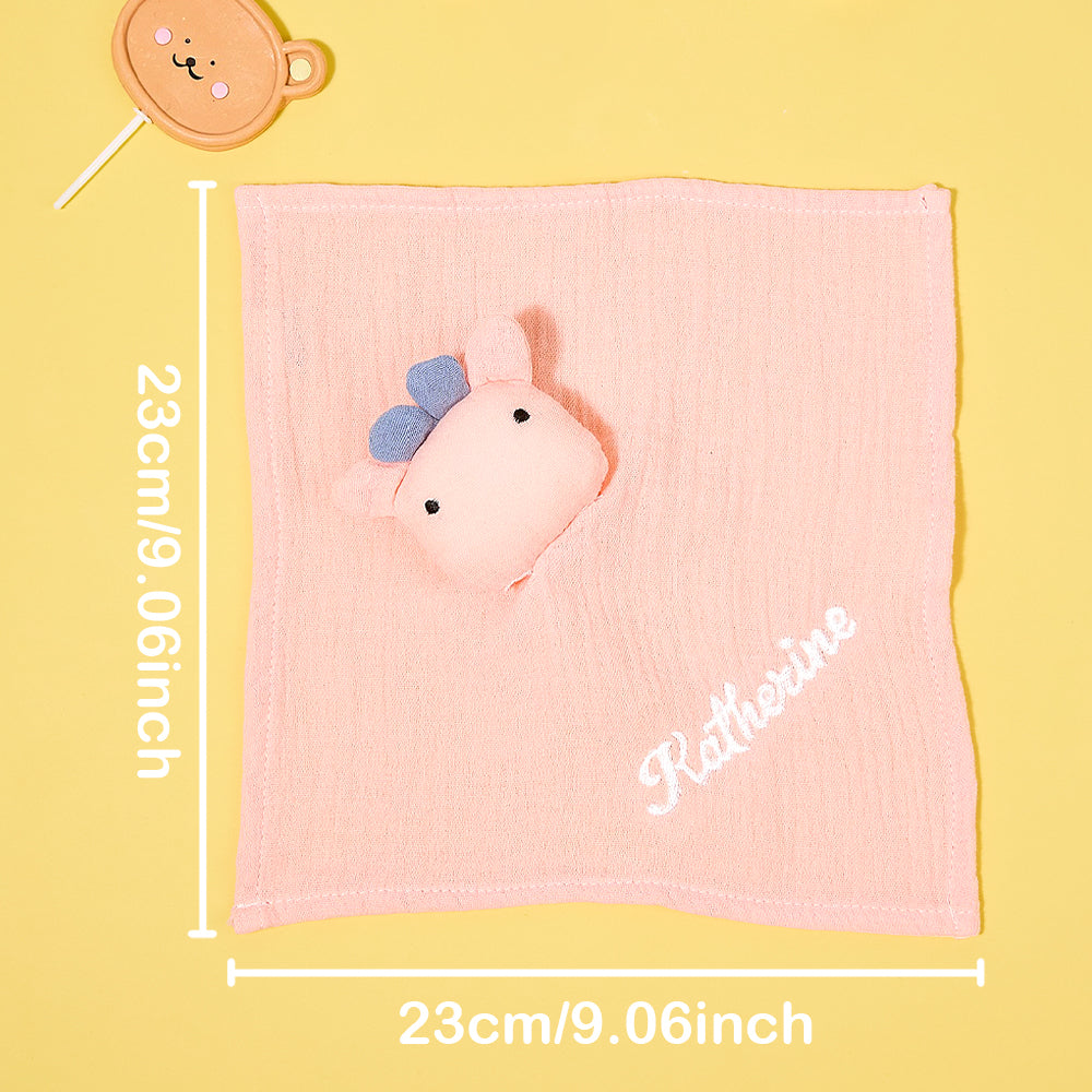 Personalised baby comforter with embroidered name beside dummy and toy, ideal small comfort blanket for cot and car seat