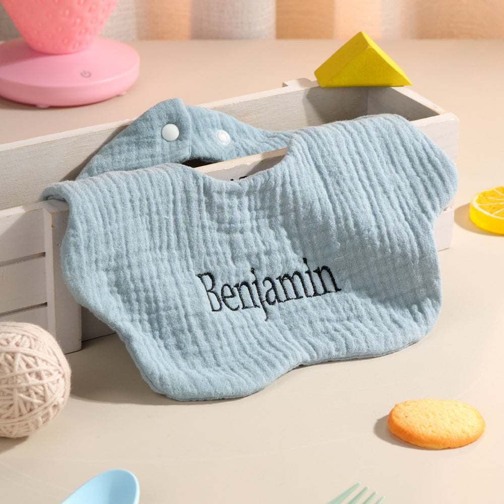Collection of personalised cotton baby bibs in different colours with embroidered names — ideal baby shower gifts