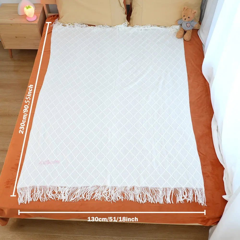Folded sample of the personalised tassel blanket highlighting embroidery and tassel border.