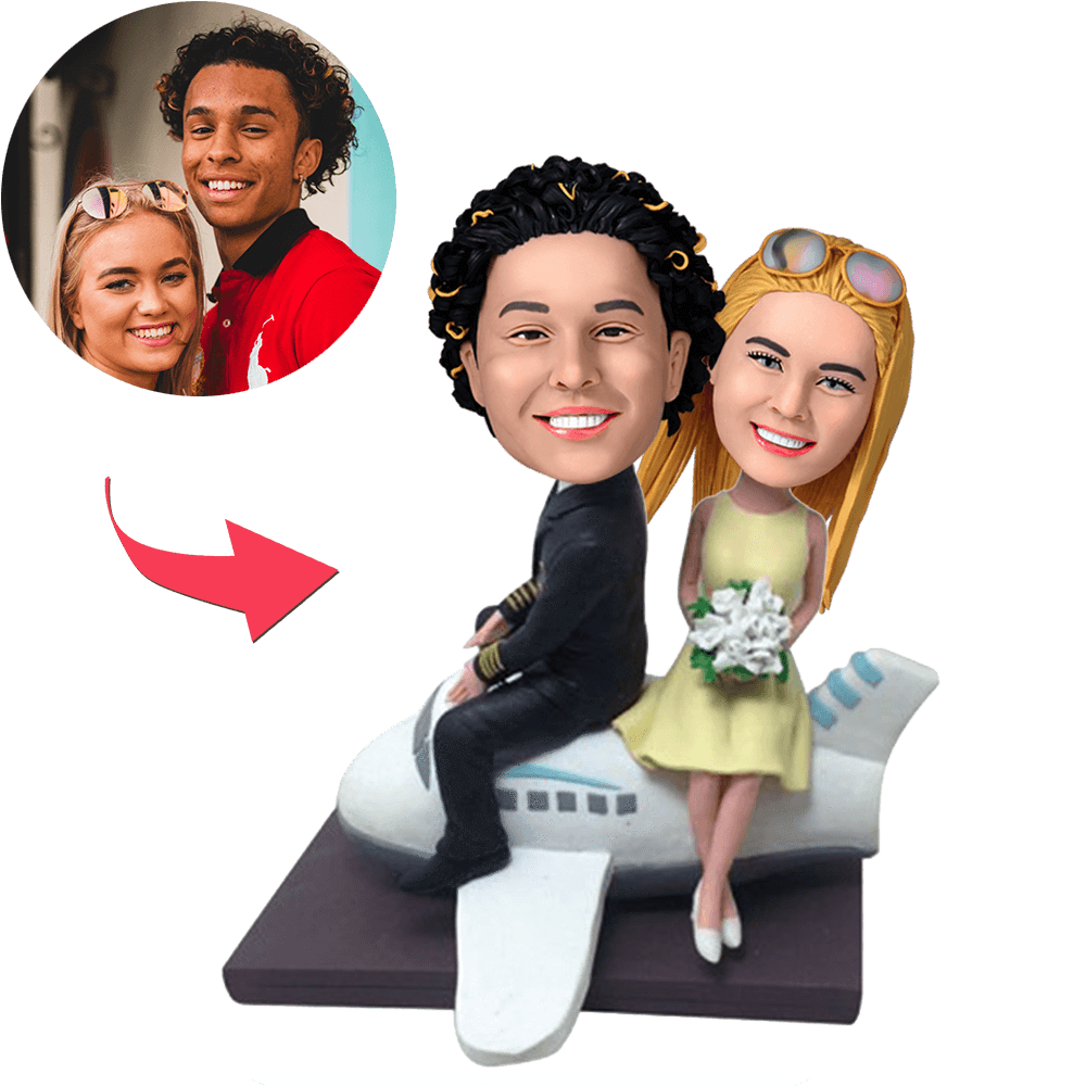 Couple On A Plane personalised bobblehead with customised heads and engraved text on the base, hand-finished polymer clay travel-themed anniversary or engagement gift