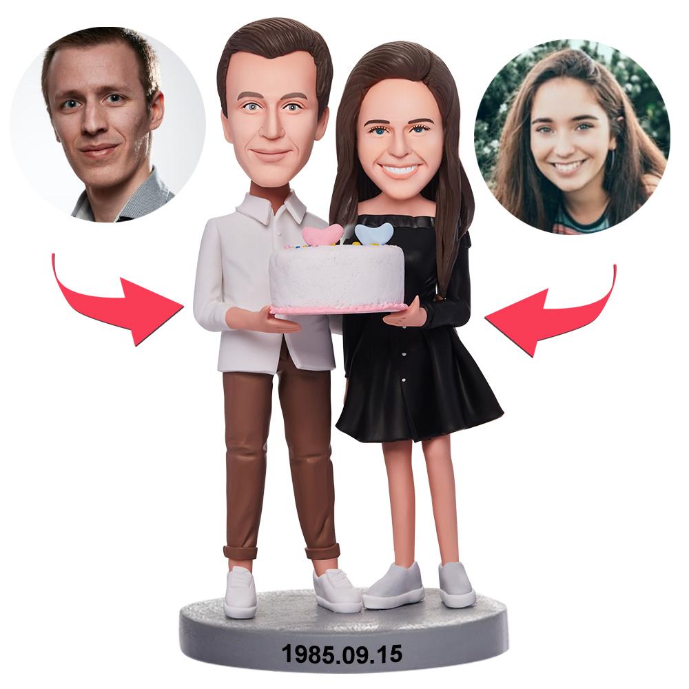 Personalised couple bobblehead holding a birthday cake – handmade polymer clay figures with custom heads from your photos, ideal personalised birthday gift for couples in the UK and Australia