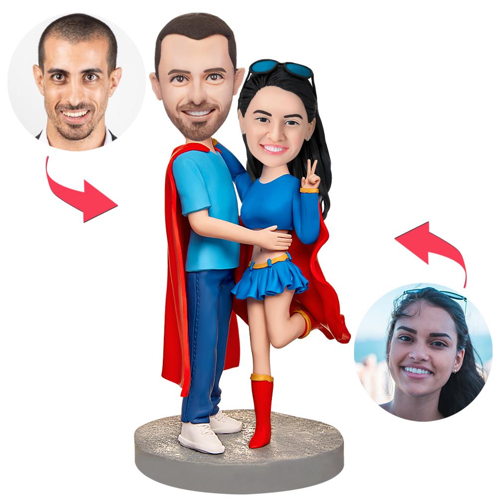 Personalised Superman couples bobbleheads in polymer clay, front view with engraved base showing custom text — personalised superhero anniversary or wedding gift