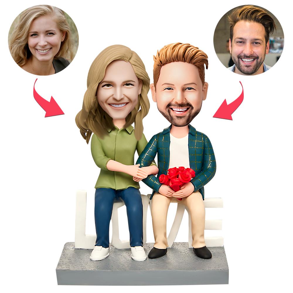 Handcrafted sitting couple personalised Valentine’s Day bobblehead in polymer clay with engraved text on the base — customised heads from your photos, ideal anniversary or engagement keepsake