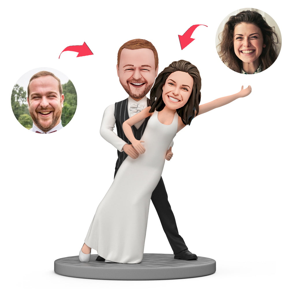 Groom holding bride personalised wedding bobblehead with engraved base — handcrafted polymer clay wedding keepsake personalised from photos