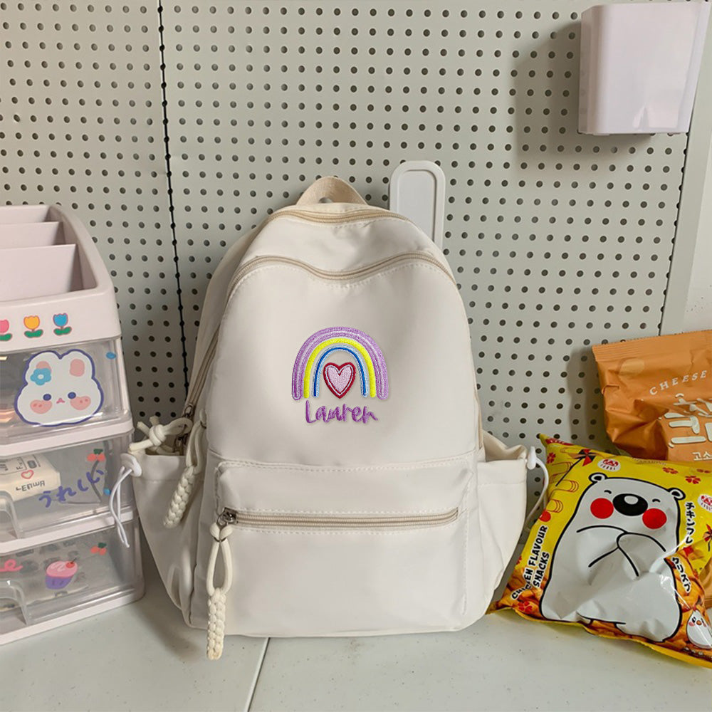 Compact personalised rainbow backpack upright, showing durable polyester and nylon finish with adjustable straps for nursery or day trips