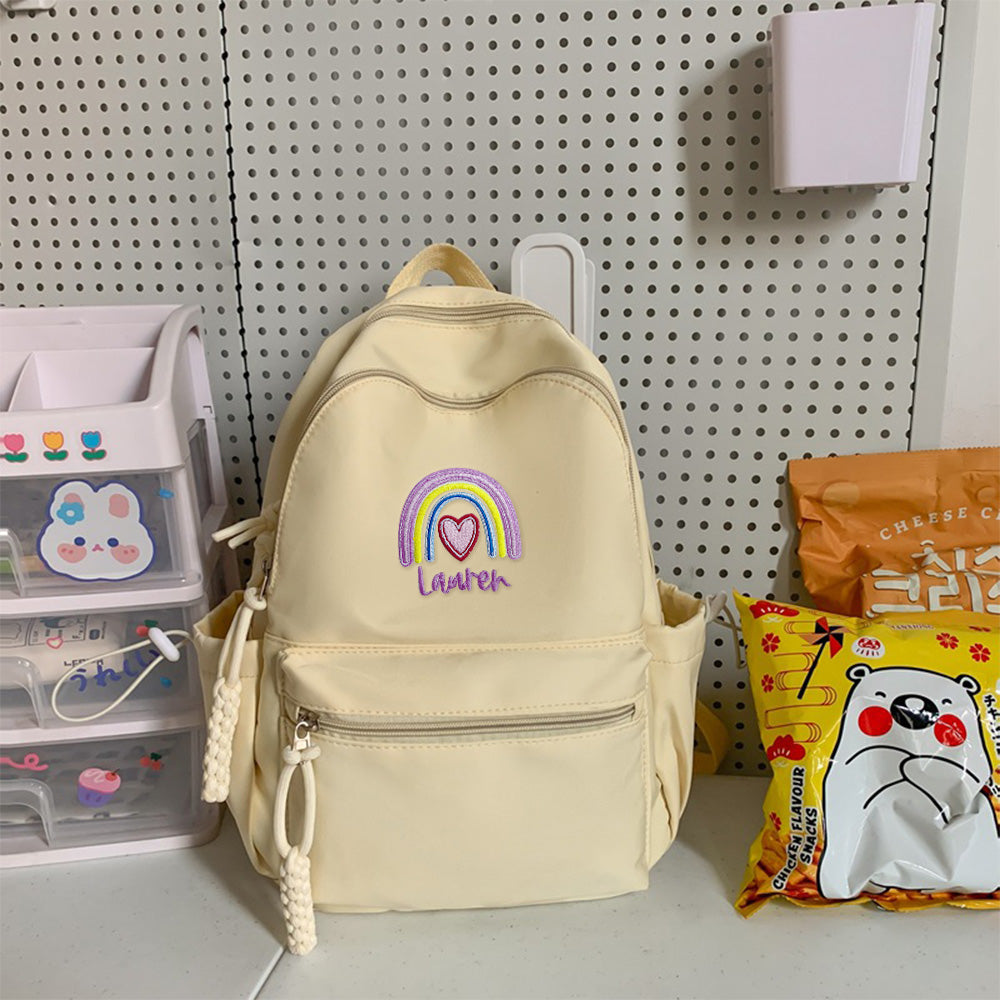 Rear view of personalised rainbow backpack showing padded adjustable shoulder straps and top carry handle for comfortable school wear