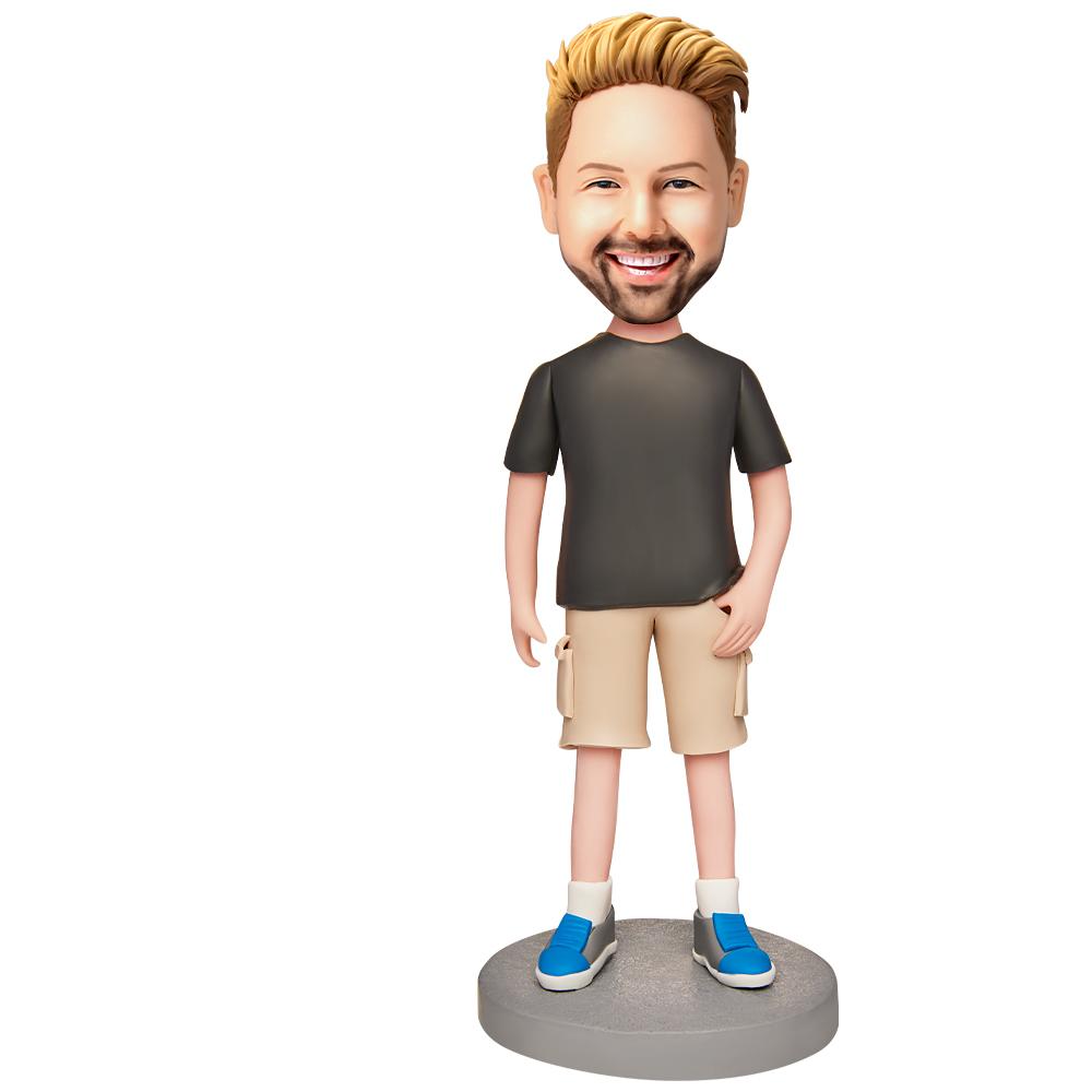 Personalised polymer clay bobblehead in casual shorts, front view — custom head with chosen hairstyle and expression and engraved text on base, ideal keepsake gift