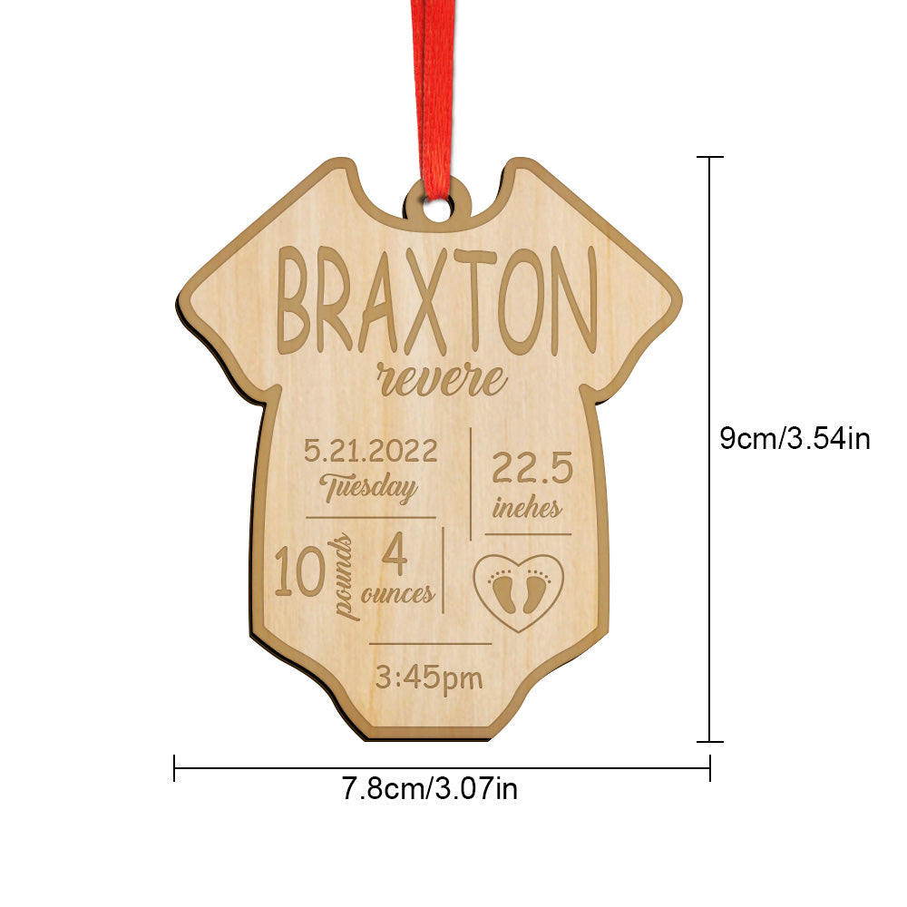 Close-up of engraved natural wood grain on a personalised baby birth ornament showing name and birth stats — bespoke wooden first Christmas keepsake