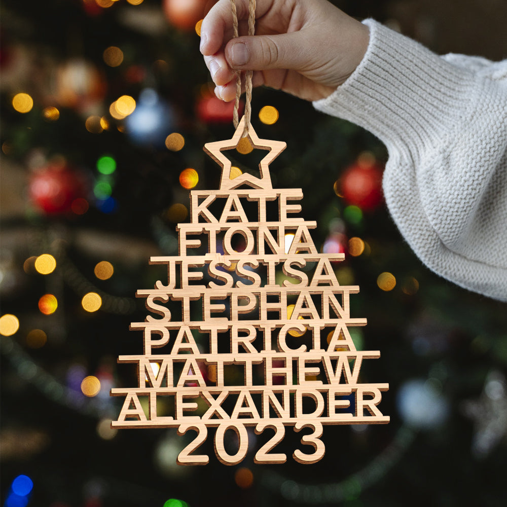 Collection of family name personalised Christmas tree ornaments displayed on a tree, bespoke wooden keepsakes and custom name decorations for generations