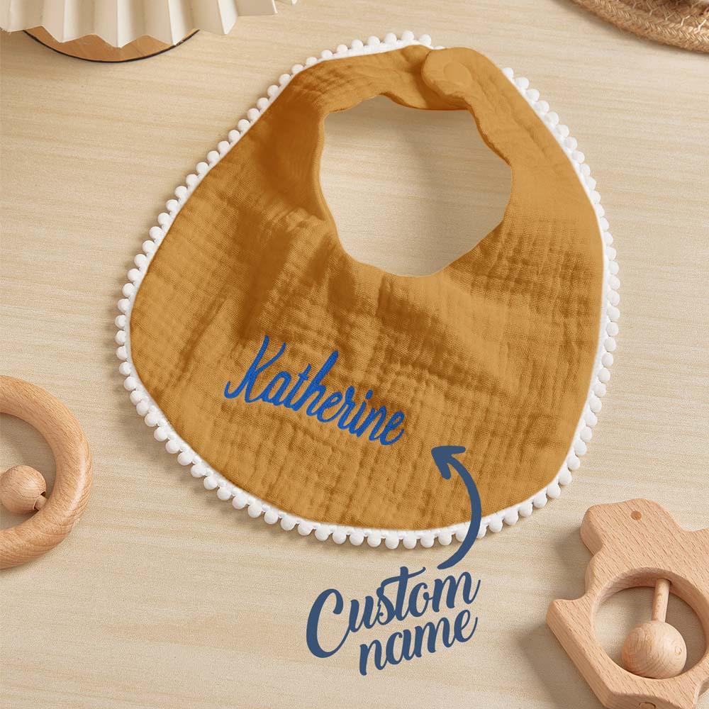 Close-up of soft cotton fabric and durable embroidered lettering on a personalised baby bib — maintains quality after washes