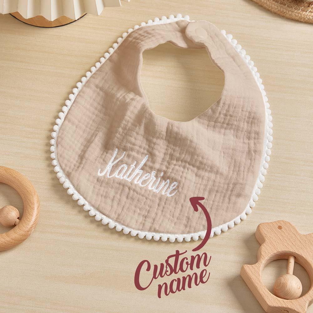 Personalised baby bib displayed with matching newborn gift items — embroidered name makes a cherished keepsake