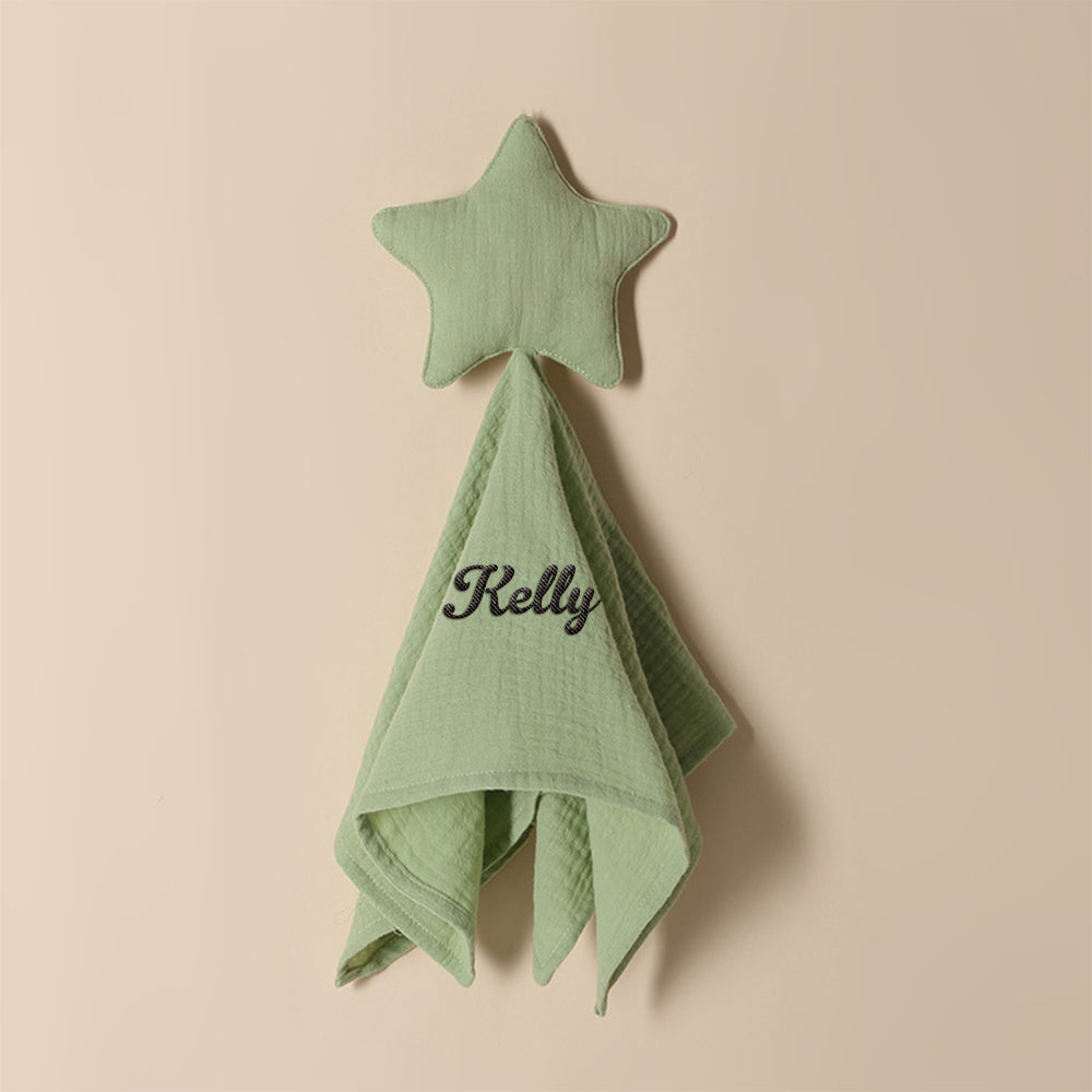 Personalised baby towel arranged with baby accessories to highlight embroidered name and star design, ideal new arrival gift