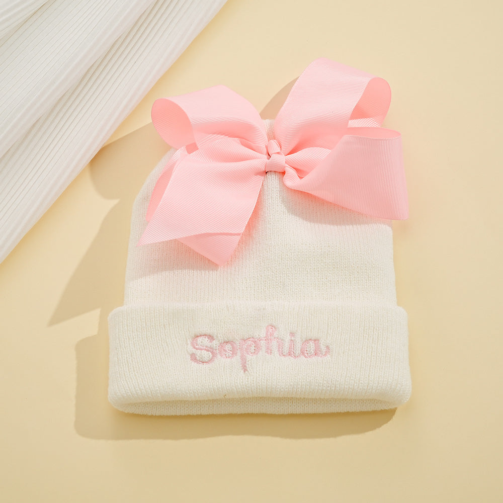 Personalised knitted baby hat with bow — custom name embroidery on soft polyester yarn, suitable for newborns and toddlers (48–54 cm)