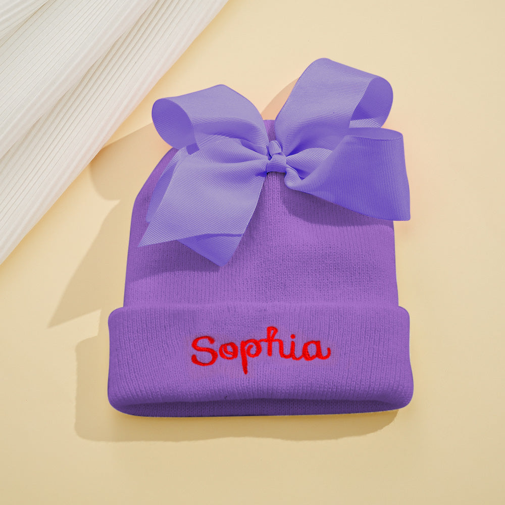 Detailed close-up of bow and stitching on personalised knit baby beanie with custom name embroidery