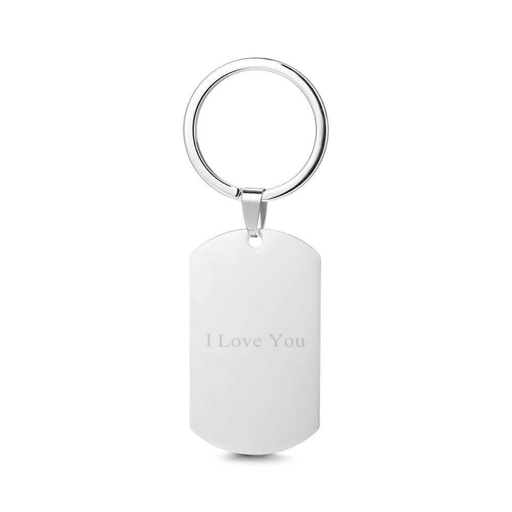 Close-up detail of personalised stainless steel photo tag showing crisp laser engraving of a portrait and clear custom text on a polished metal face