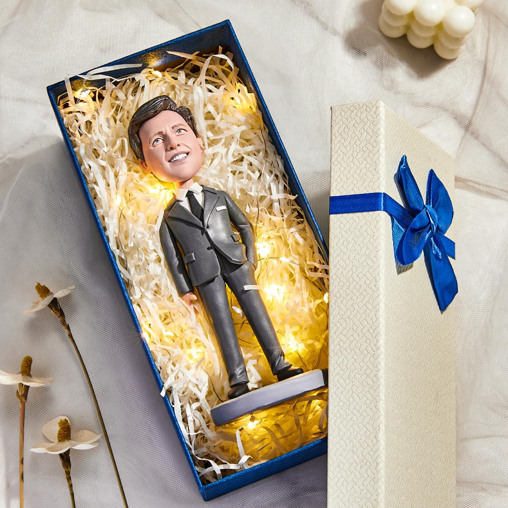 Close-up of personalised bobblehead showing engraved base reading "World's Best Boss" and lifelike customised head — engraved office keepsake and thank-you gift for mentors