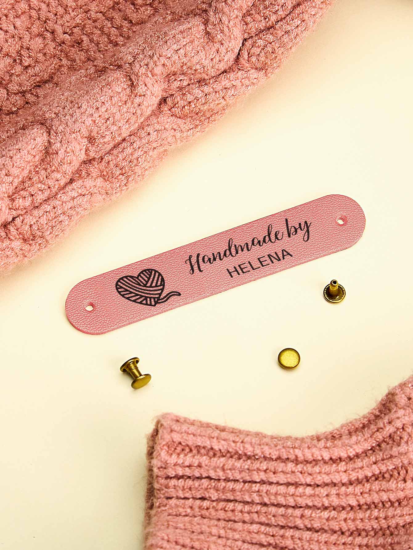 Custom PVC labels featuring engraved-style text ideal for knitted hats and scarves