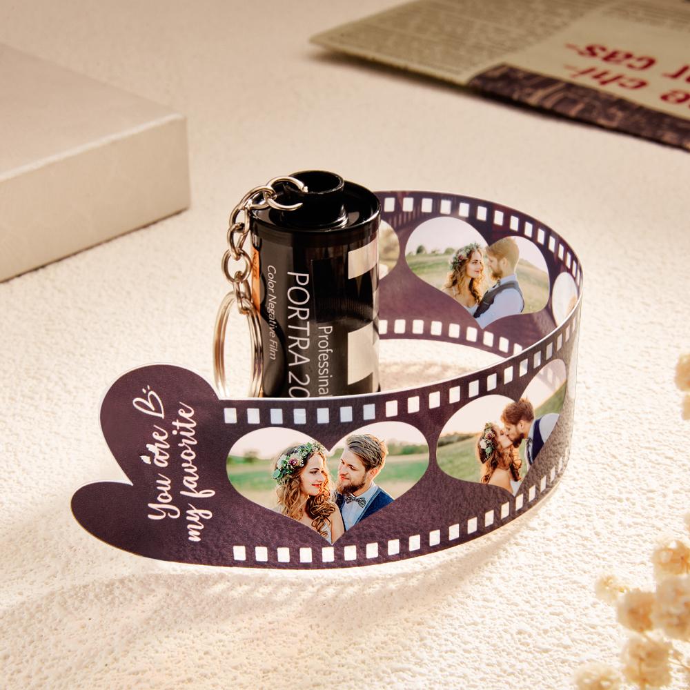 Front view of the personalised keychain attached to a bag, illustrating the camera-roll heart photo layout and print quality.