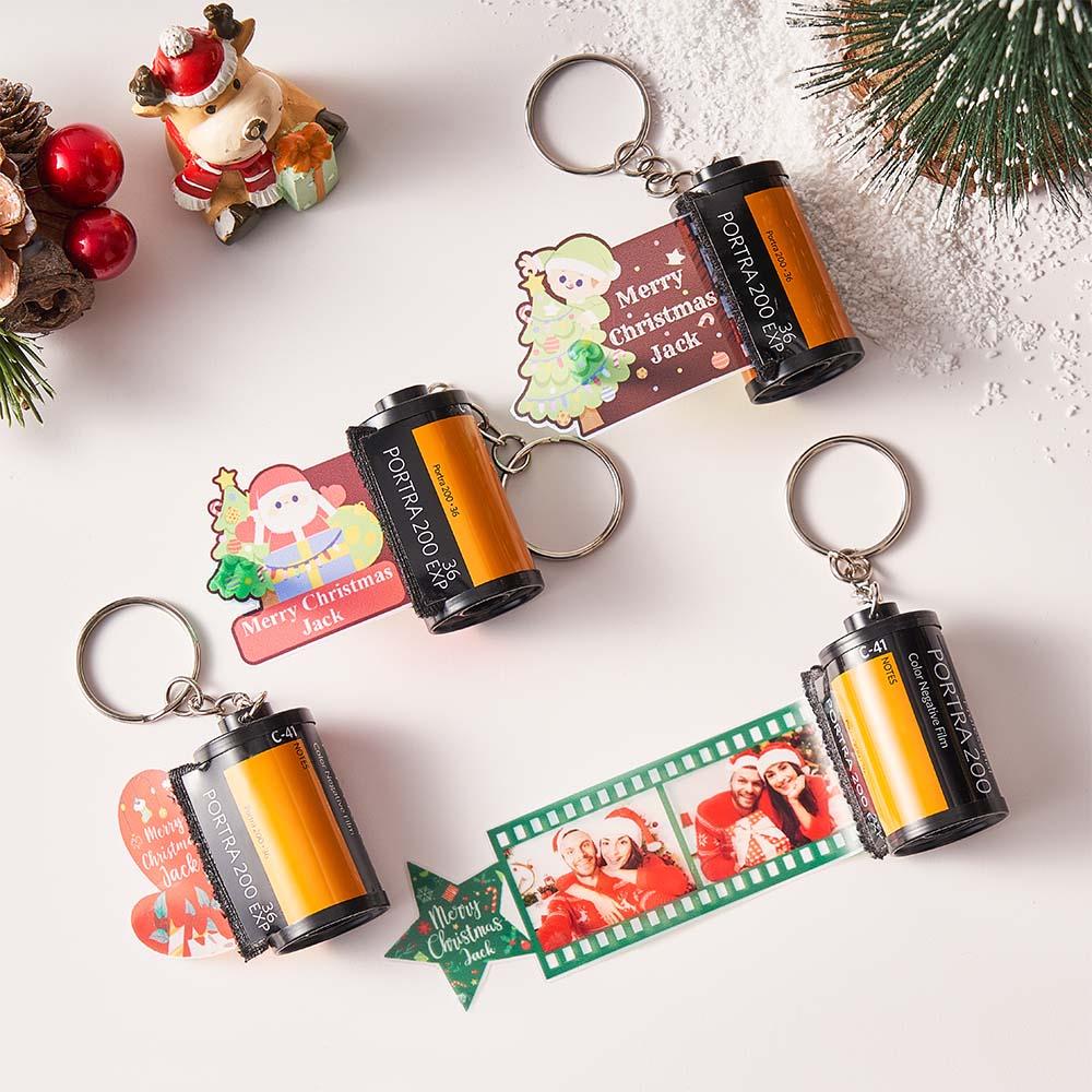 Personalised camera film roll keychain close-up showing film-strip design with inserted photos and custom text — custom photo keyring gift