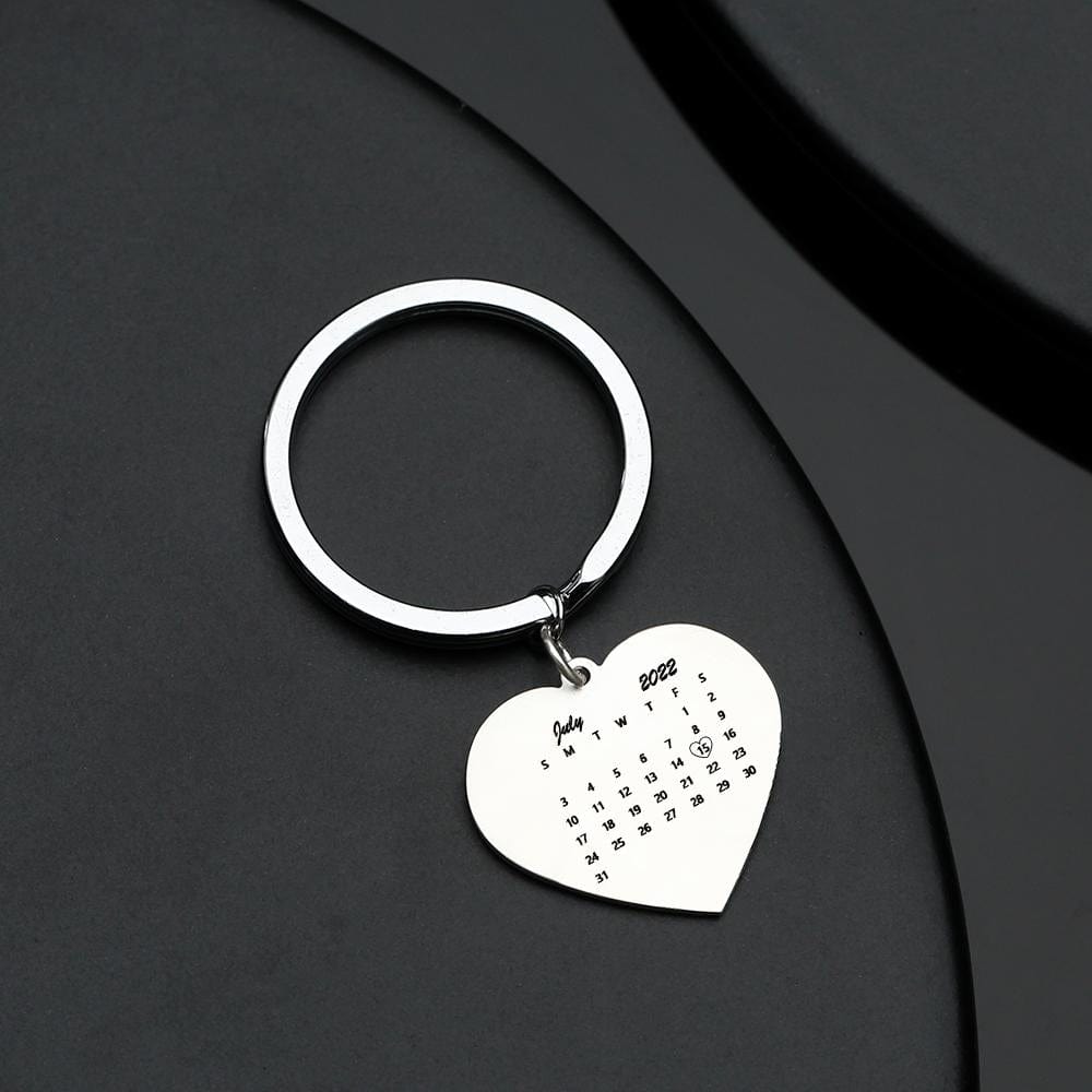 Close-up of personalised stainless steel heart keyring showing engraved calendar date and inserted photograph — a romantic anniversary keepsake