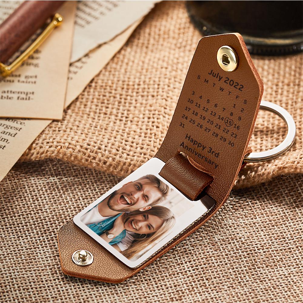 Close-up of engraved leather strap on personalised keychain, clear laser-engraved text and shiny metal buckle — engraved leather keyring