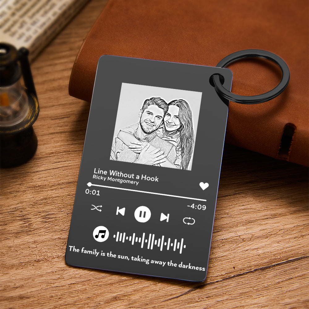 Close-up of custom metal music plaque showing engraved scannable music code, personalised text and photo on brushed stainless steel keyring