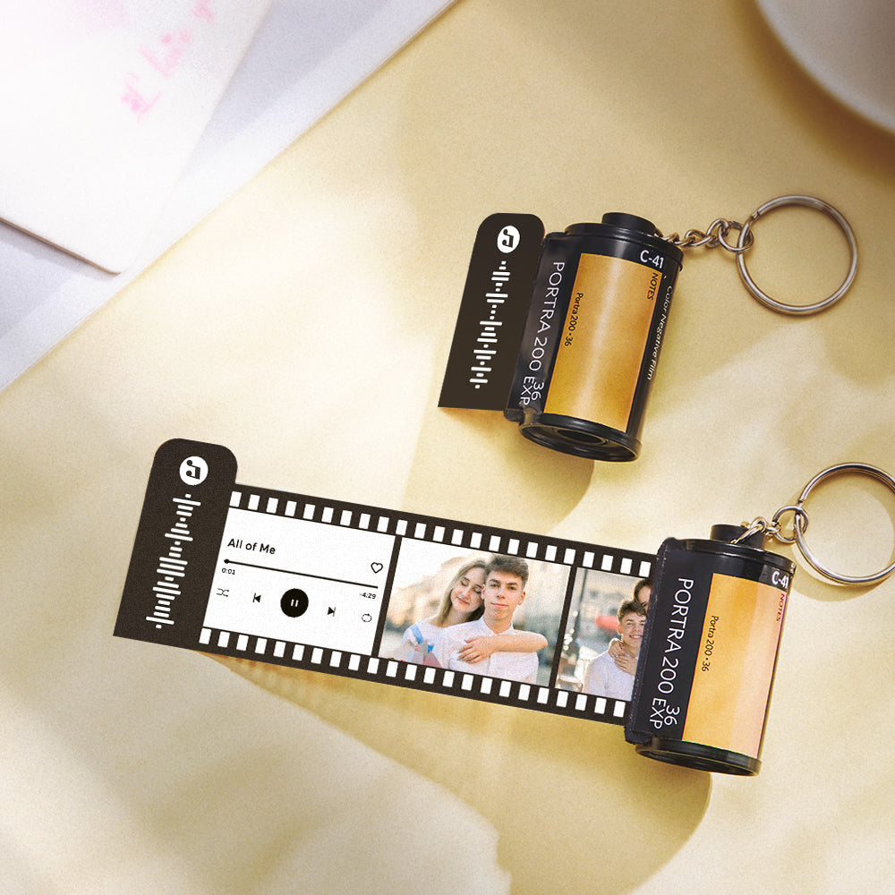Custom photo film keyring showing sliding vintage film strip and music code — unique personalised keepsake keychain