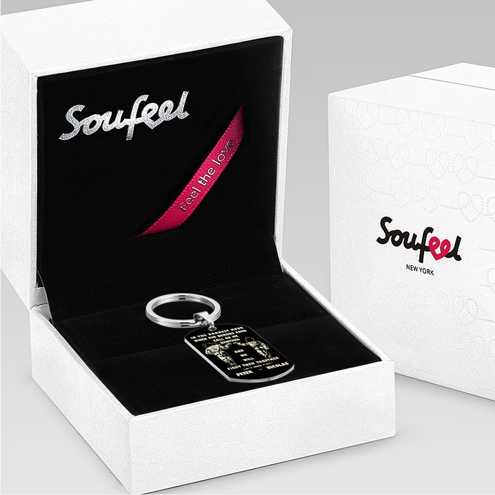 Close-up showing the engraved tag mounted on a split-ring beside personal items to show real-world scale and use.